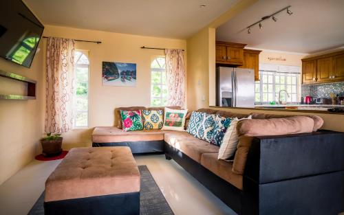 ein Wohnzimmer mit einem Sofa und einem Tisch in der Unterkunft flamboyantvilla in Gros Islet
