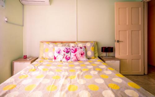 a bedroom with a bed with yellow and pink pillows at flamboyantvilla in Gros Islet