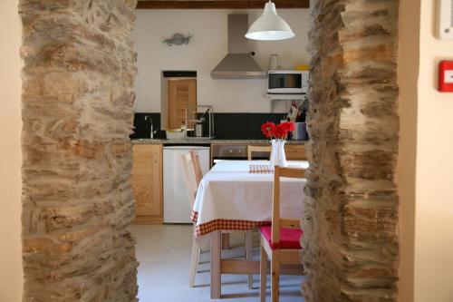 a kitchen and dining room with a table and chairs at Casas da Nascente in Loriga