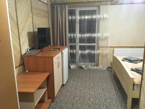 a room with a desk and a bed and a window at Skarbivka in Vorokhta