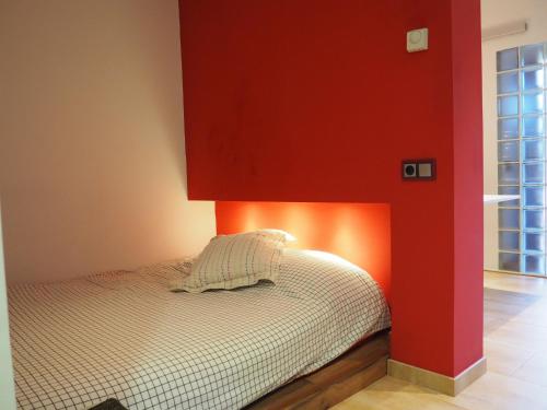 a bedroom with a bed with a red wall at apartamento aislado jardín y piscina in Sant Andreu de Llavaneres