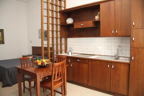 una cucina con armadi in legno e un tavolo con un cesto di frutta di Residence I Due Pini a Marina di Grosseto