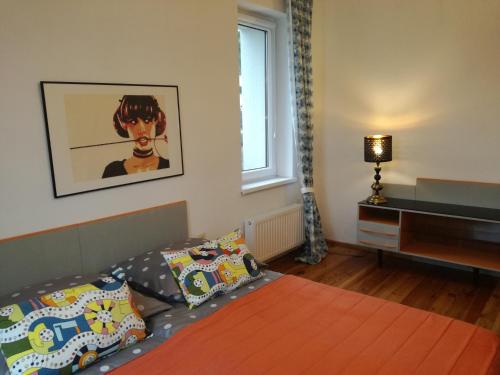 a bedroom with a bed and a desk and a window at Apartament Mamamiry in Głuchołazy