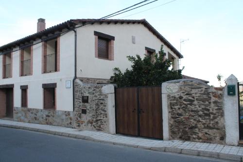 una casa con una puerta de madera en el lateral de una calle en Casa Rural Leonor con piscina privada, en Casar de Palomero