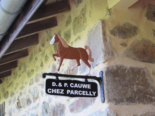 un cartel en una pared con un caballo. en La vache sur le toit en Montagny