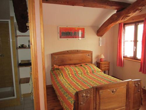 - une chambre avec un lit en bois et une couette verte dans l'établissement La vache sur le toit, à Montagny