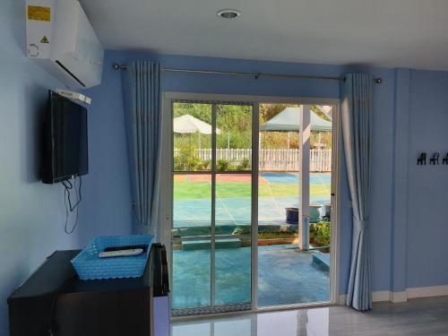 a living room with a sliding glass door to a pool at Bunny Hill Resort in Chon Buri