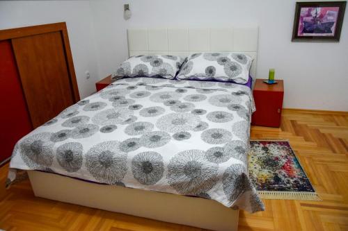 una camera da letto con un letto con un piumone e cuscini di Apartman MAŠA a Banja Luka