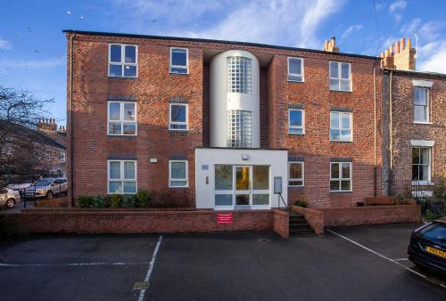 a brick building with a parking lot in front of it at Riverbank View Three Bedroom Apartment with Free Parking in York
