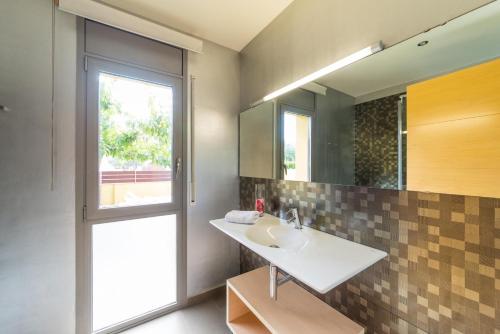 ein Bad mit einem Waschbecken und einem Spiegel in der Unterkunft Villa Marianna in L'Escala