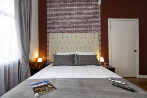 a bedroom with a large bed with a brick wall at TERRA PREMIUM Hostal Boutique in Quito