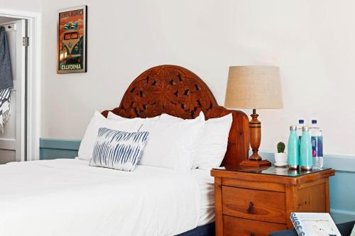 a bed with a wooden headboard next to a table with a lamp at Sea Blue Hotel in Los Angeles