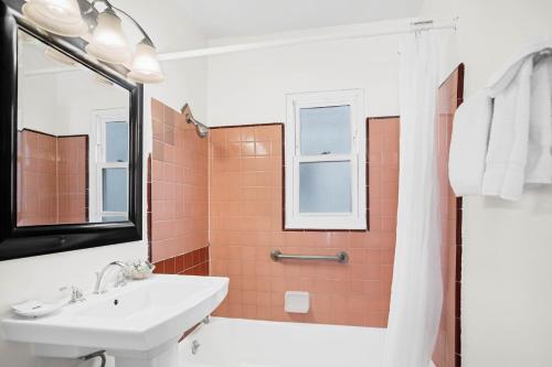 a bathroom with a sink and a shower with orange tiles at Sea Blue Hotel in Los Angeles