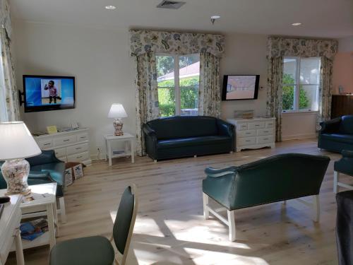 a living room with blue furniture and windows at Epworth By The Sea in Saint Simons Island