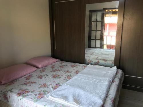 1 cama con 2 almohadas y espejo en una habitación en Casa Praia Rasa, en Búzios