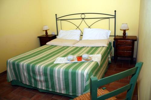 a bedroom with a bed with a green and white striped blanket at Agriturismo Le Docce in Castelfiorentino