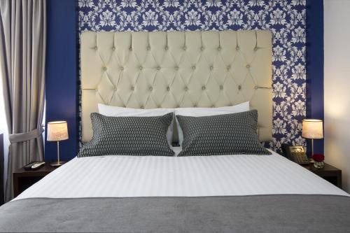 a bedroom with a large bed with a blue wall at TERRA PREMIUM Hostal Boutique in Quito