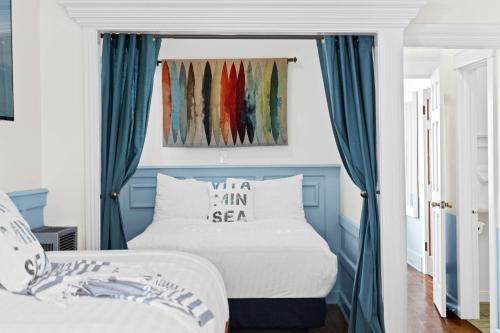 a bedroom with a bed with blue curtains at Sea Blue Hotel in Los Angeles