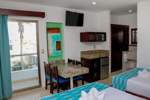 a room with two beds and a kitchen with a table at Playa Linda Hotel in Progreso