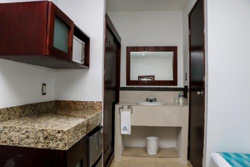 a small bathroom with a sink and a mirror at Playa Linda Hotel in Progreso