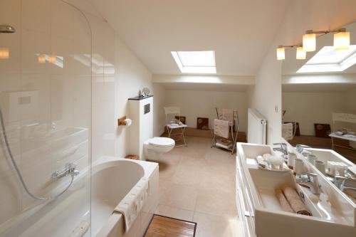 ein Badezimmer mit einer Badewanne, einem Waschbecken und einem WC in der Unterkunft B&B Hof van Vervoering in Voeren