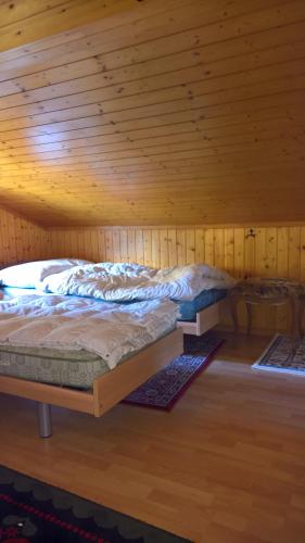 a bed in a room with a wooden ceiling at Chalet Sven & Marc Grächen, Niedergrächen Vallis in Sankt Niklaus