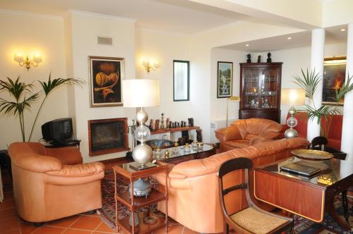 a living room with leather furniture and a table at Vivenda Belo Horizonte in Caniço