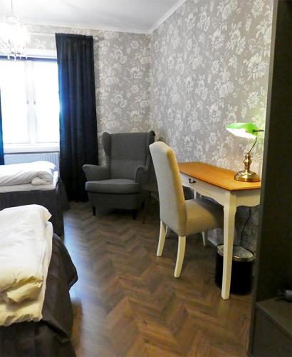 a room with a desk and a chair and a bedroom at Anno 1908 Torpshammars Herrgård in Torpshammar