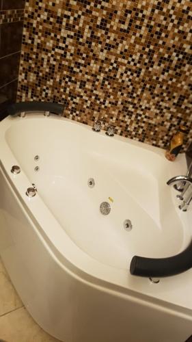 a white bath tub sitting in a bathroom at Pompeii Ruins De Charme B&B in Pompei