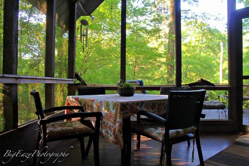 a table and chairs in a screened in porch at The River Chalet in Folsom