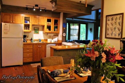 a kitchen with a table and a white refrigerator at The River Chalet in Folsom