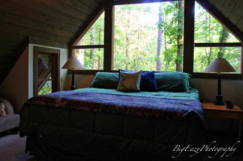 a bedroom with a bed in a room with windows at The River Chalet in Folsom