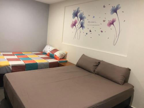 a room with two beds and a painting on the wall at Budget for 12 in Ipoh