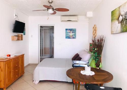 a small bedroom with a bed and a table at Vert Pays in Fort-de-France