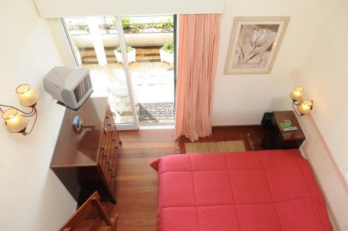 a living room with a red couch and a window at Vivenda Belo Horizonte in Caniço