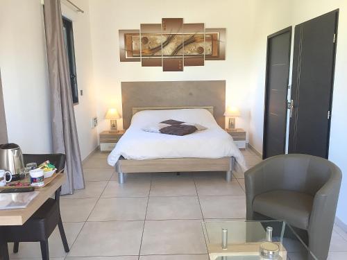 a bedroom with a bed and a desk and a chair at L'ESCALE COTE BLEUE B&B AND Spa in Sausset-les-Pins