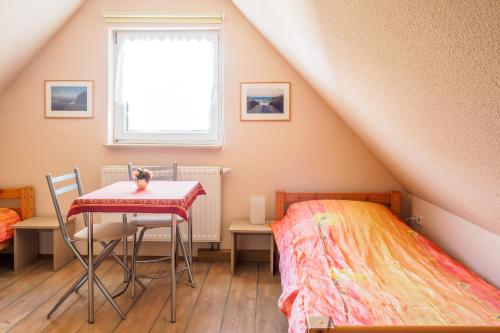 a bedroom with a table and a bed and a window at Ferienhaus Seegras in Trassenheide