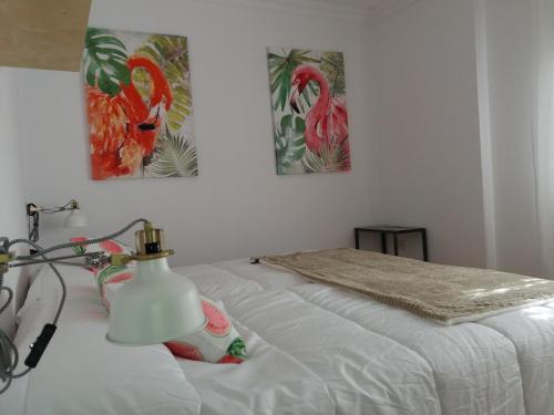 ロス・ジャノス・デ・アリダネにあるUrban home Aridane 1のベッドルーム1室(壁に絵画2点が飾られたベッド1台付)