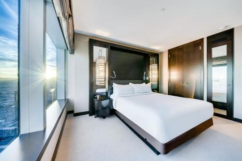 a bedroom with a large white bed and large windows at Jet Luxury at The Vdara in Las Vegas