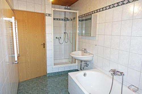 a bathroom with a bath tub and a sink and a bath tub at Ferienwohnung mit Wasserbett FW3 in Saalfeld