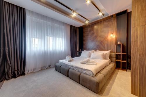 ein Schlafzimmer mit einem Bett und einem großen Fenster in der Unterkunft Black Pearl Luxury Suites in Belgrad