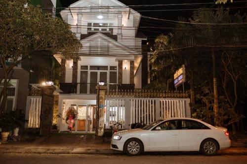 a white car parked in front of a house at night at Tuyet Suong Villa Hotel in Quang Ngai