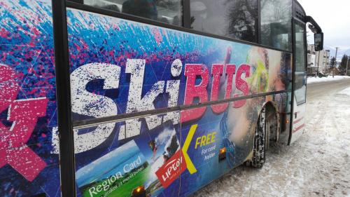 a bus is parked on the side of the road at Apartmany Vila Vista in Demanovska Dolina
