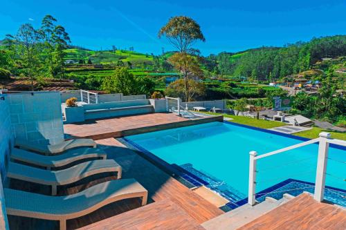 a swimming pool with a deck and stairs next to a house at Hilldale Retreat in Nuwara Eliya
