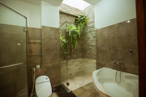 y baño con ducha, bañera y aseo. en Tuyet Suong Villa Hotel, en Quảng Ngãi