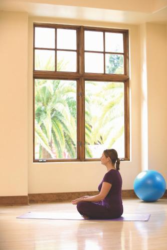 a woman sitting in a yoga pose in front of a window at Fairmont Sonoma Mission Inn & Spa in Sonoma