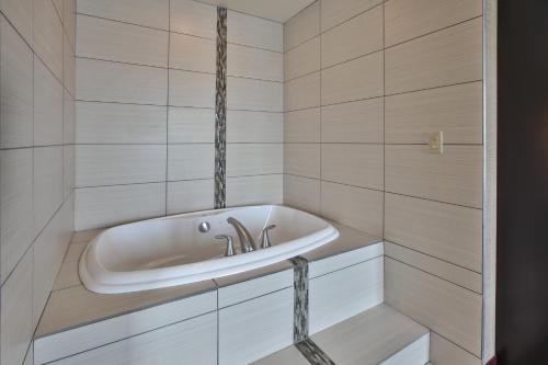 uma casa de banho com banheira e lavatório em Holiday Inn Express & Suites Geneva Finger Lakes, an IHG Hotel em Geneva