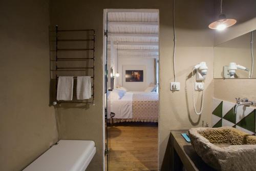 a bathroom with a tub and a bedroom with a bed at WUNDERGARTEN Dimora dei Frati in Gratteri