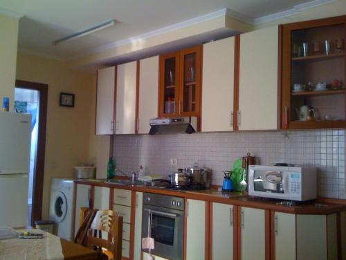 eine Küche mit weißen Schränken und einer Mikrowelle auf der Theke in der Unterkunft Ap Relax , Golem - Mali robit in Golem