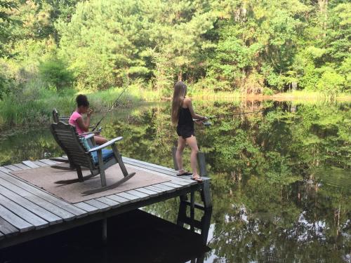 two people fishing on a dock on a lake at The River Chalet in Folsom